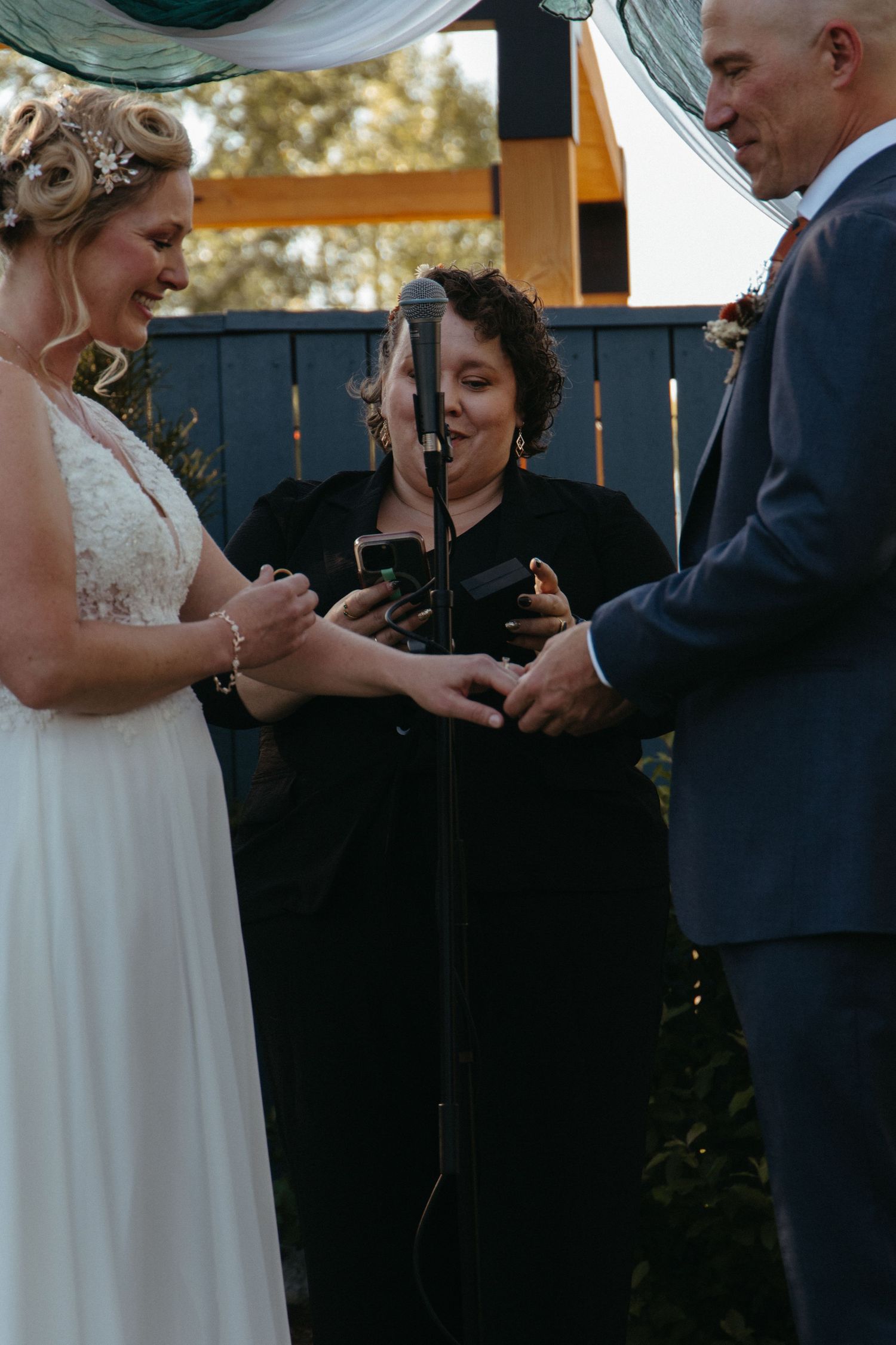 A couple exchanges rings during an intimate outdoor wedding ceremony.