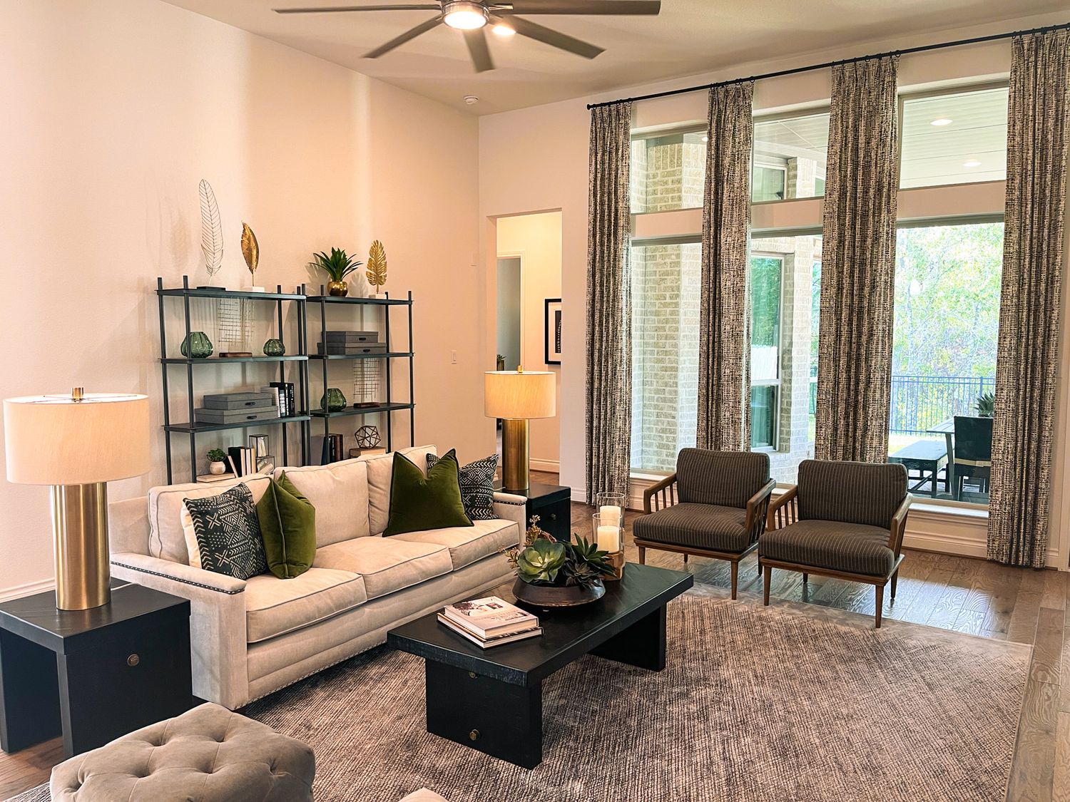 Modern living room with white sofa, gray rug, and industrial shelving decorated in neutral tones.