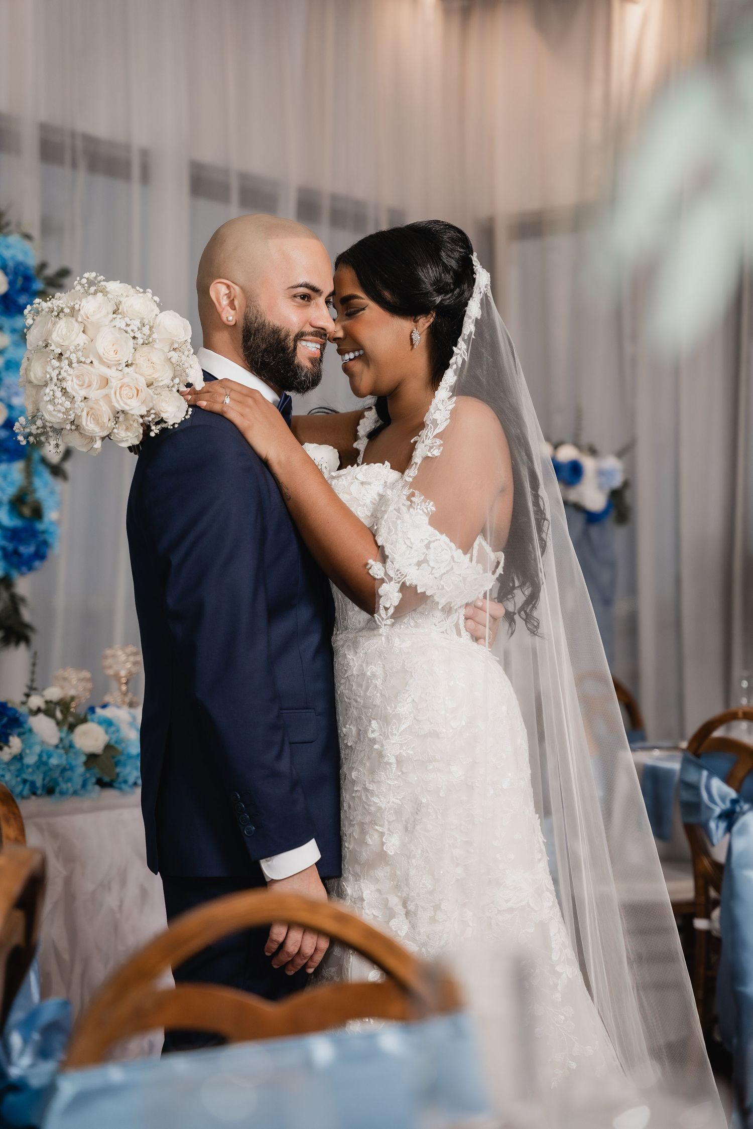 Romantic wedding portrait with white floral bouquet and blue decor accents.