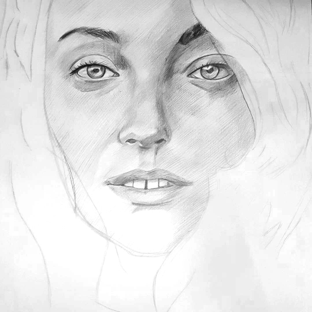 Soft pencil drawing portrait of a woman with flowing hair and expressive eyes on white paper.