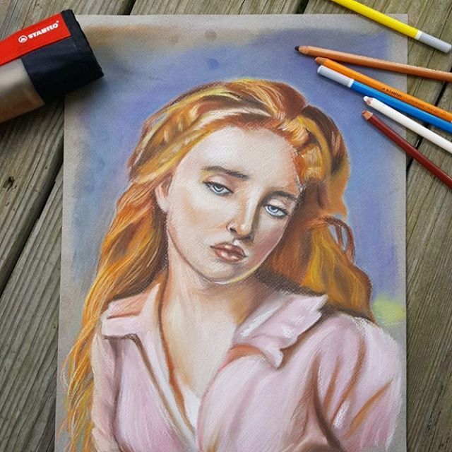 Pastel portrait drawing of a woman with auburn hair in a pink shirt.