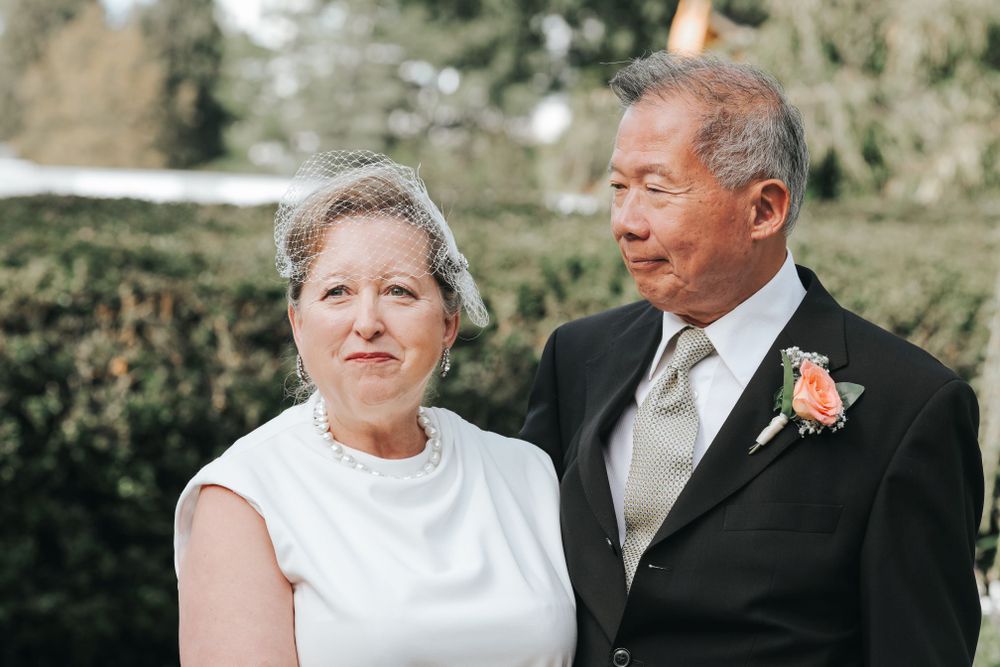Elegant couple in formal attire at an outdoor wedding celebration.