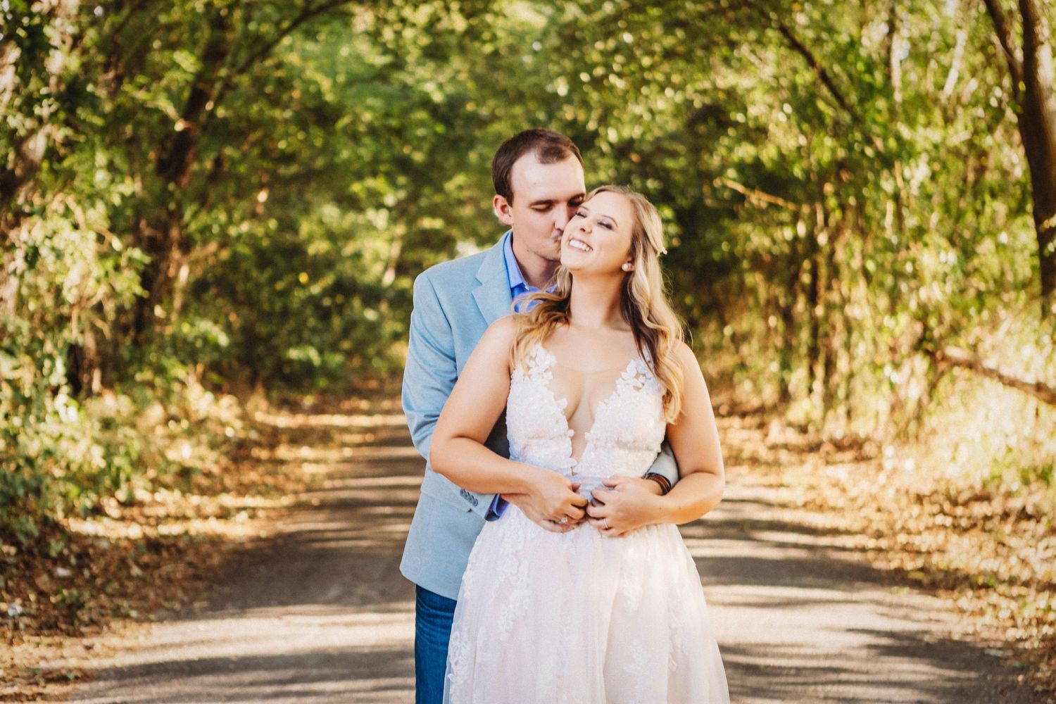 Couple sharing an intimate moment in a sunlit outdoor setting.