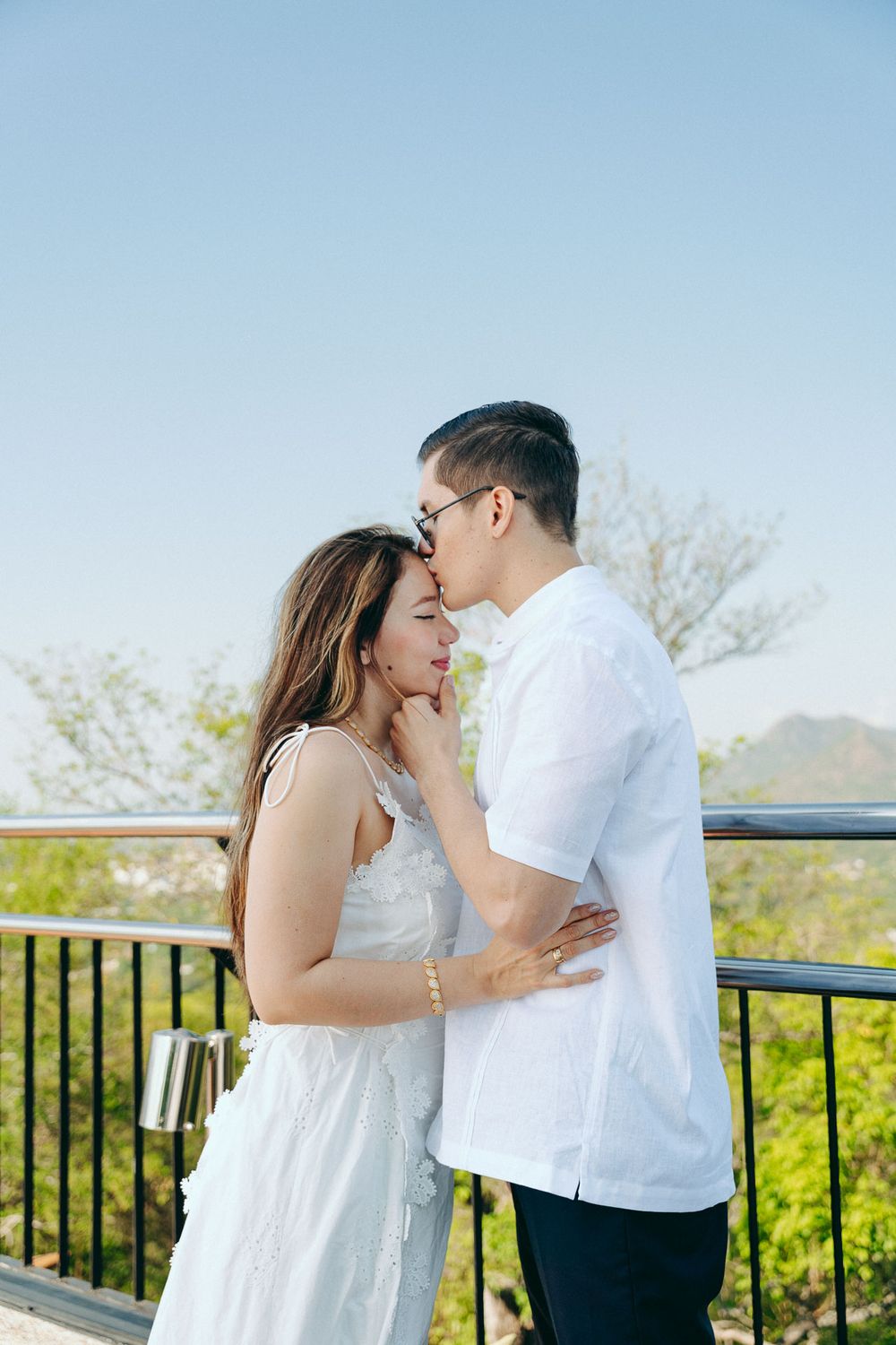 Novios besándose con el skyline de Valledupar de fondo, capturados por fotógrafo de bodas bajo estética cinematográfica.