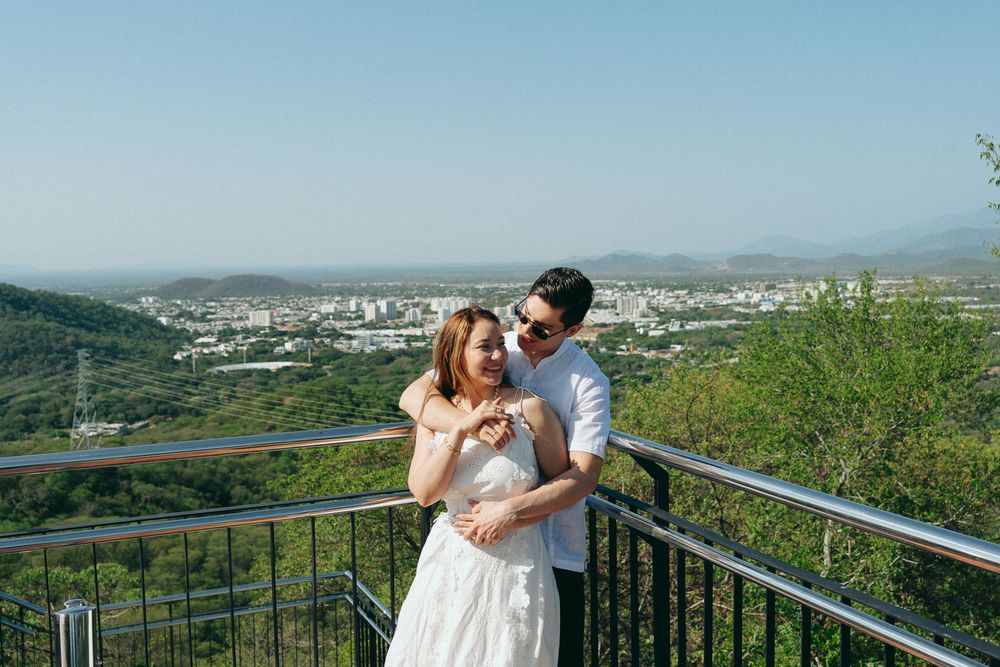 Novios besándose con el skyline de Valledupar de fondo, capturados por fotógrafo de bodas bajo estética cinematográfica.