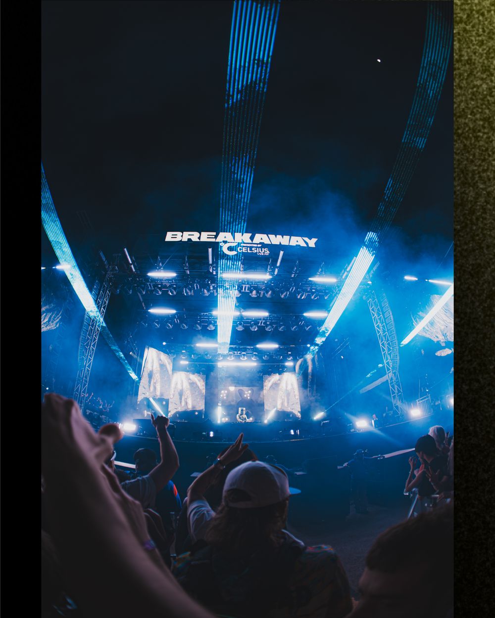 Breakaway Columbus music festival stage with vibrant blue lights, fog effects, and crowd silhouettes cheering at night.