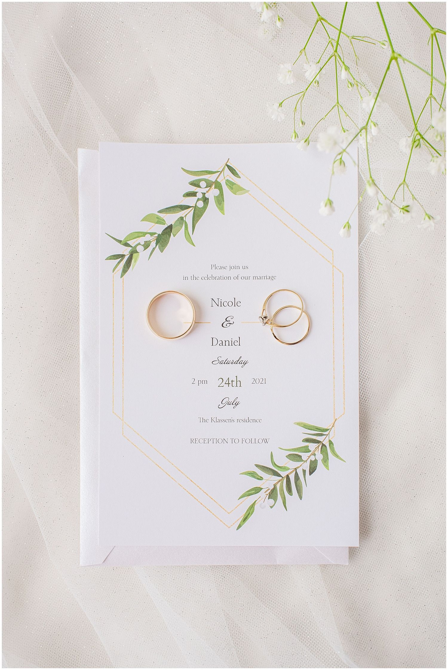 Wedding invitation for Nicole and Daniel on July 24th with gold rings and greenery botanical design.
