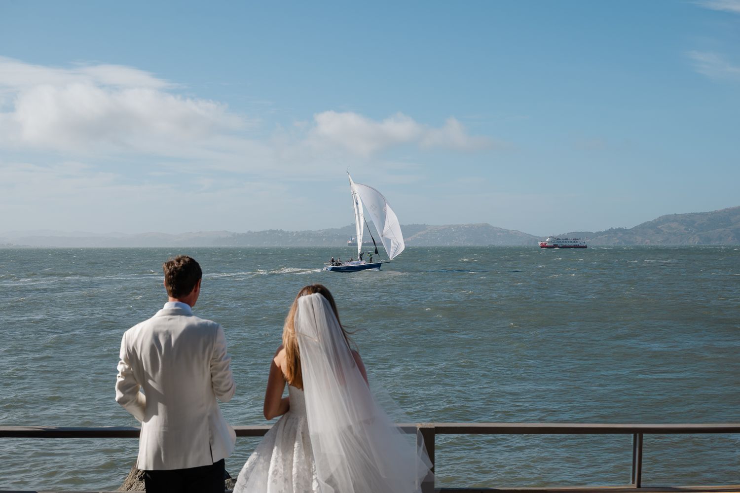 Elegant wedding ceremony at San Francisco City Hall, couple standing on grand marble staircase rotunda with seated guests.