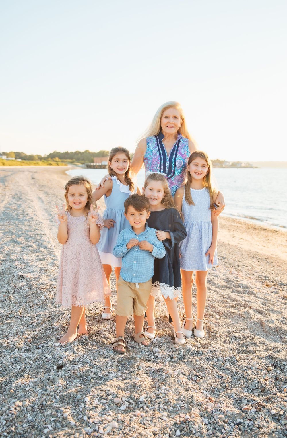 Woman and five children smiling together on a sunny beach.. extended family photoshoot Portsmouth RI