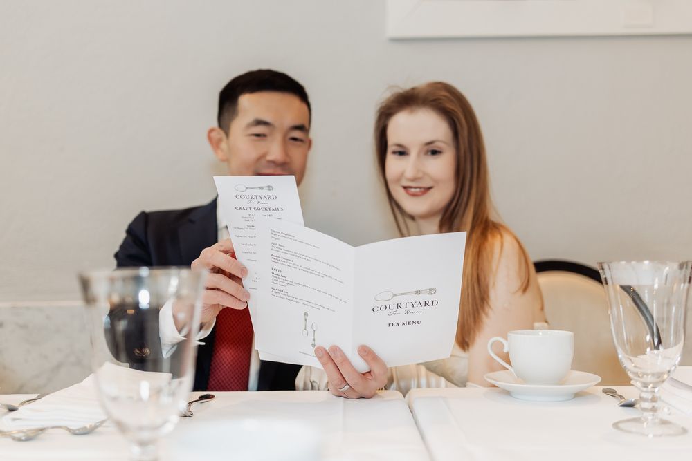 Couple reviewing a Courtyard restaurant menu together at an elegantly set dining table.