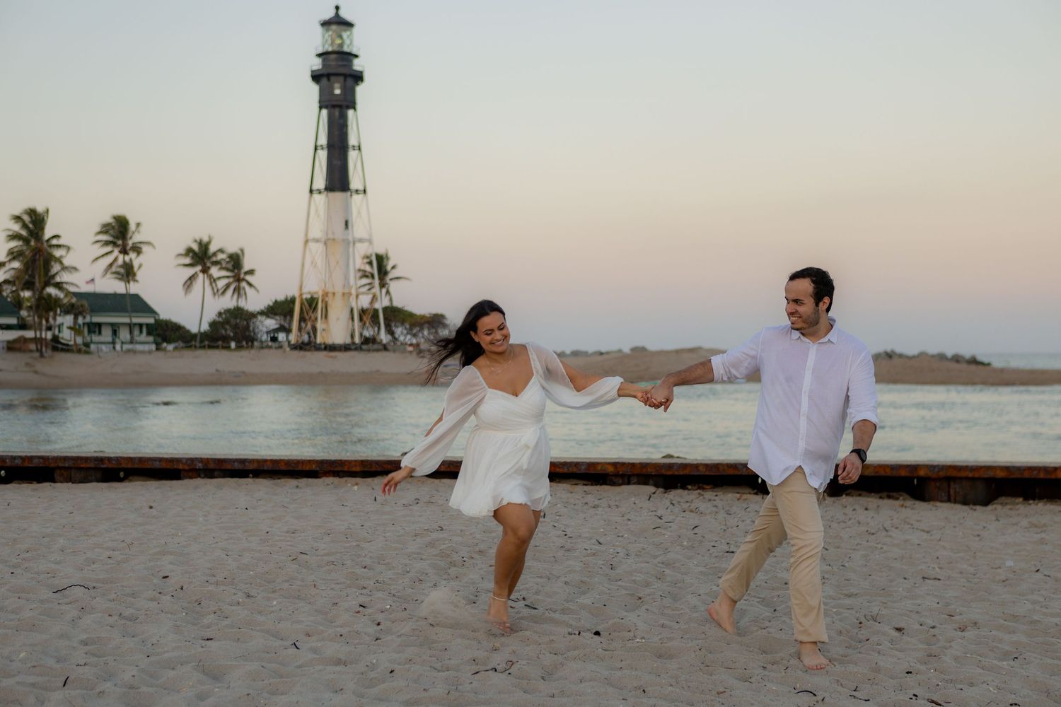 Pompano Beach engagement session featuring a private beach path and lighthouse views