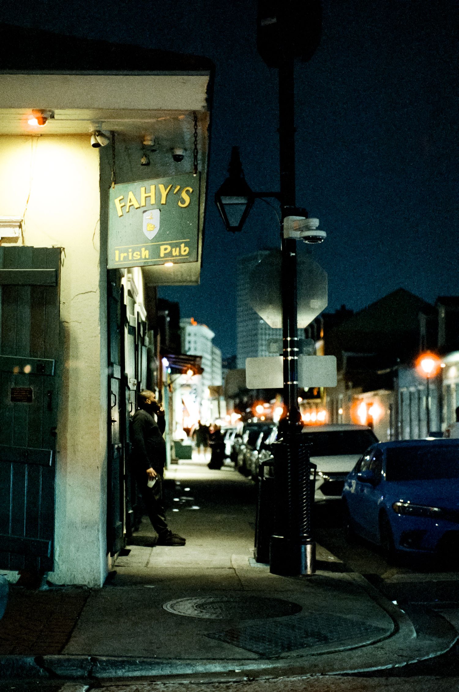 View of Fally's Irish Pub storefront and street corner at night with glowing lamps.