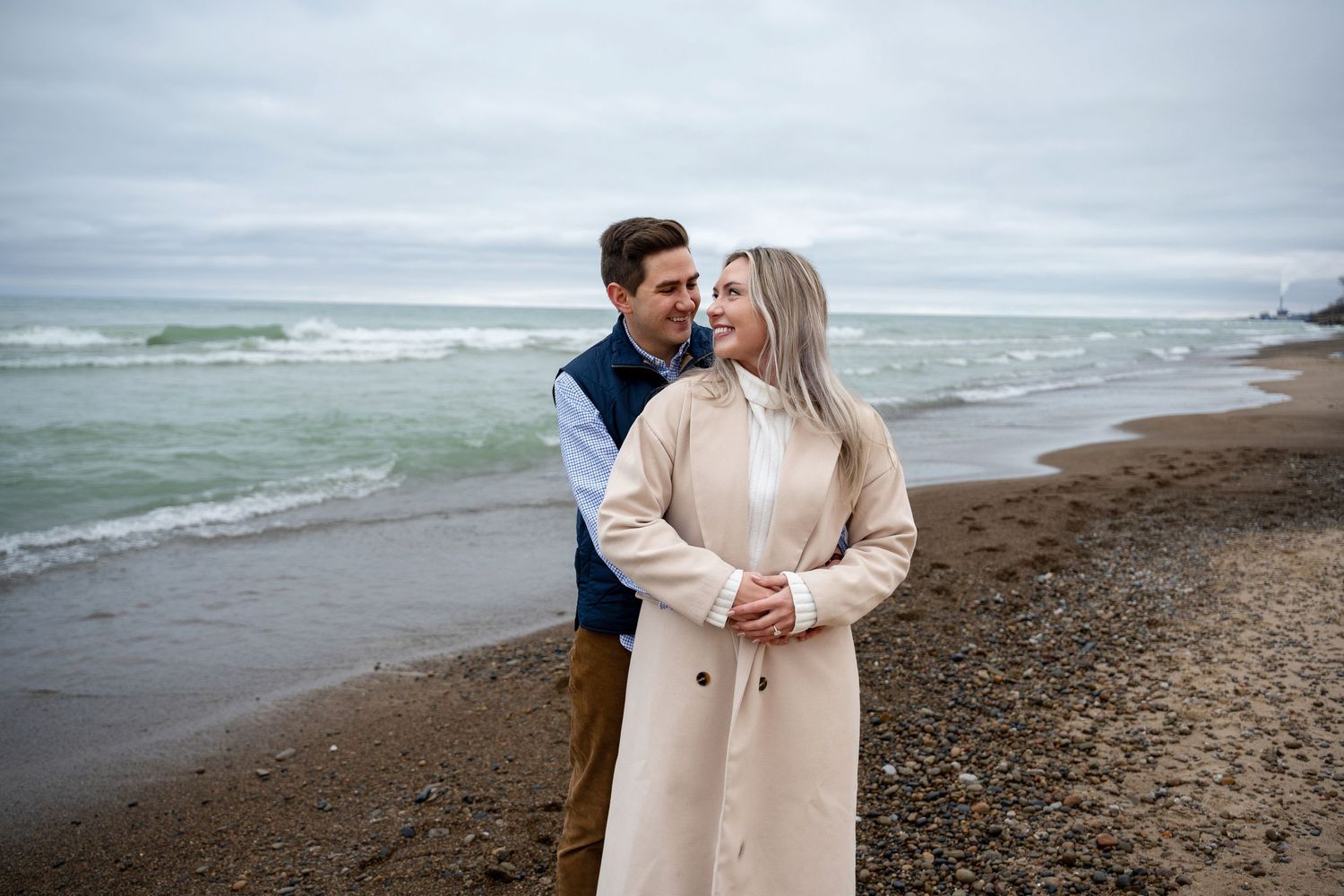 Engagement photo of couple holding each other on the beach in Chicago.