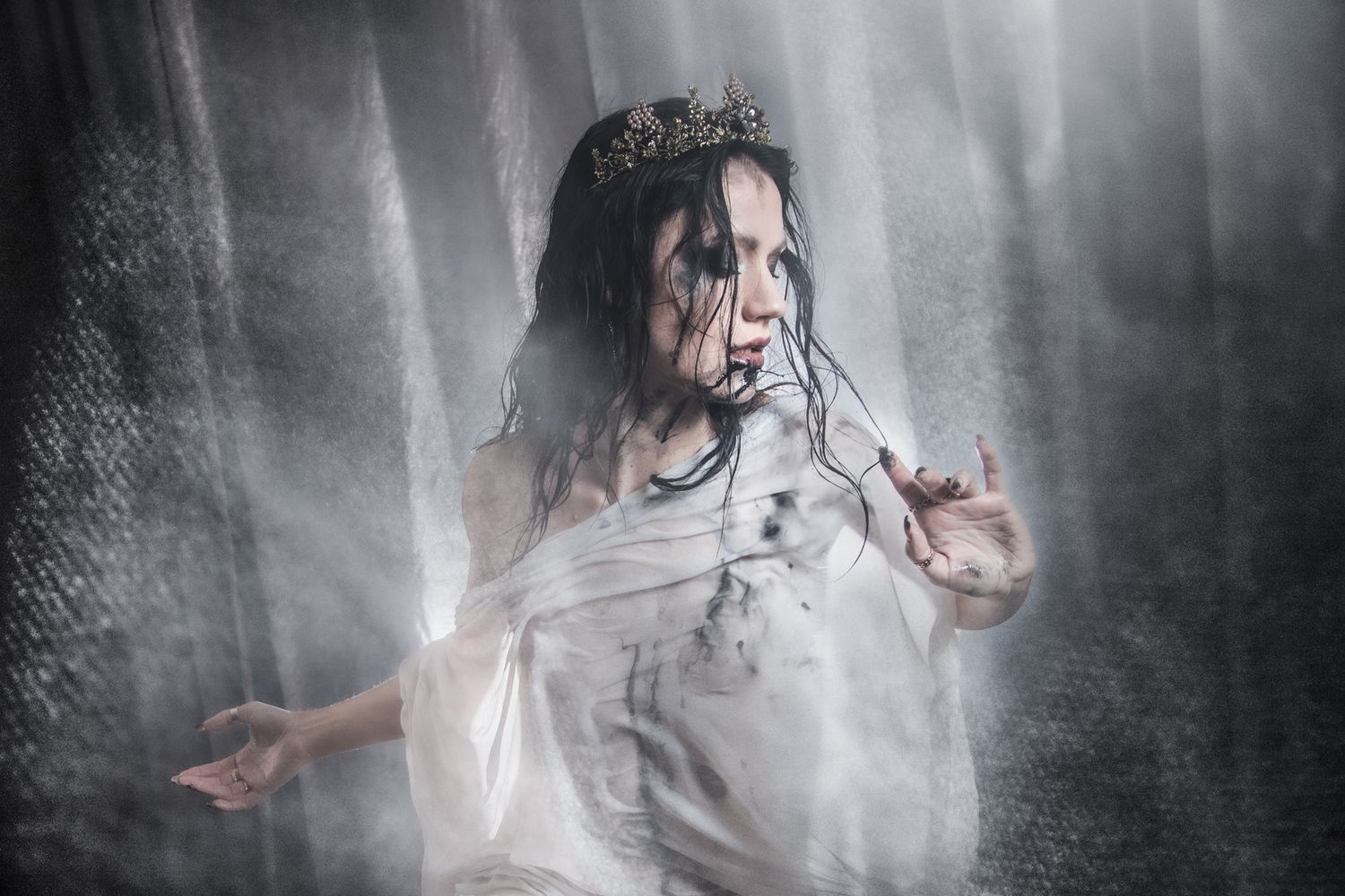 Ethereal artistic portrait in white dress with misty atmospheric effects.