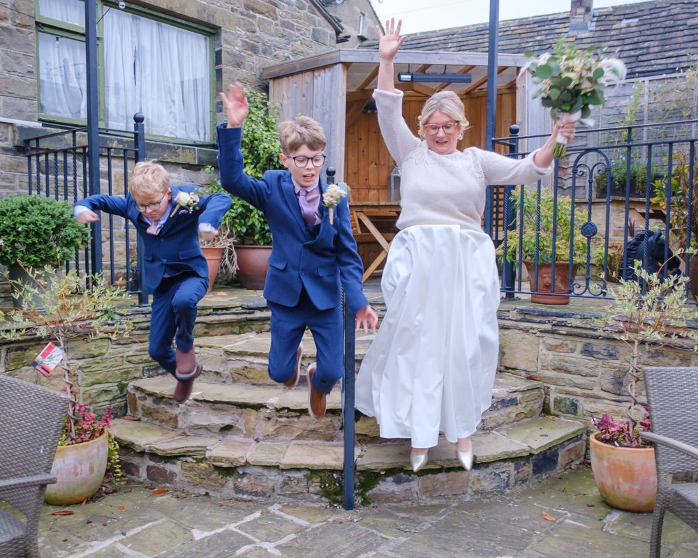 Bride jumping and having fun with her two sons at the Black Horse in Clifton