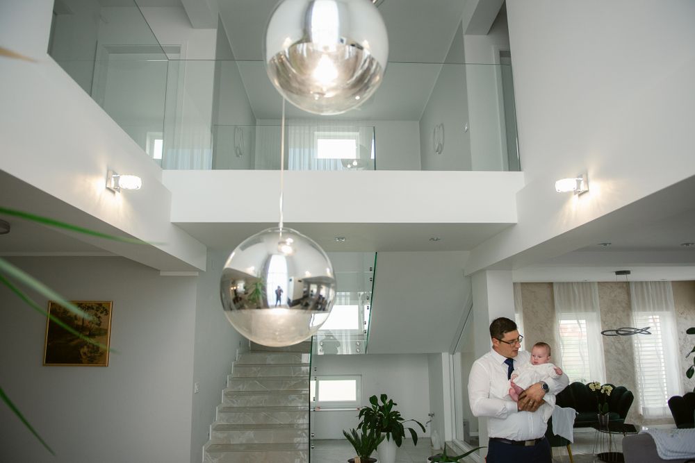 Modern interior with chrome pendant lights, white staircase and high ceilings in an open-concept office space.