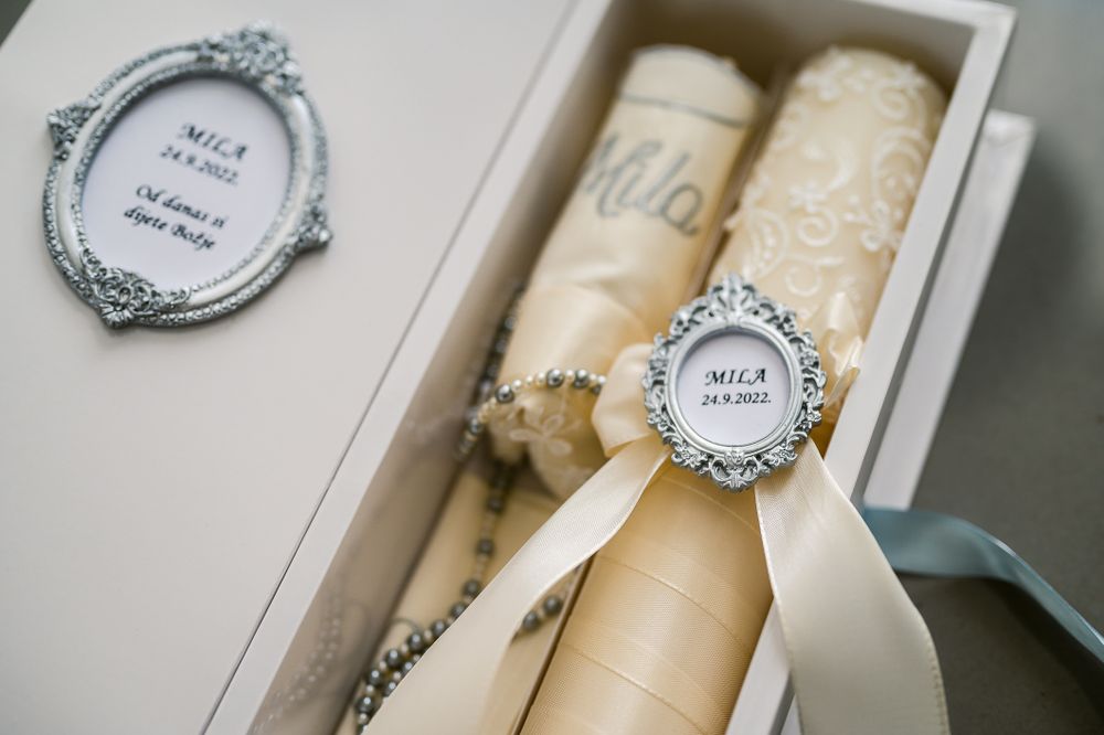 Elegant wedding scrolls with decorative silver frames and embellishments displayed in a white box.