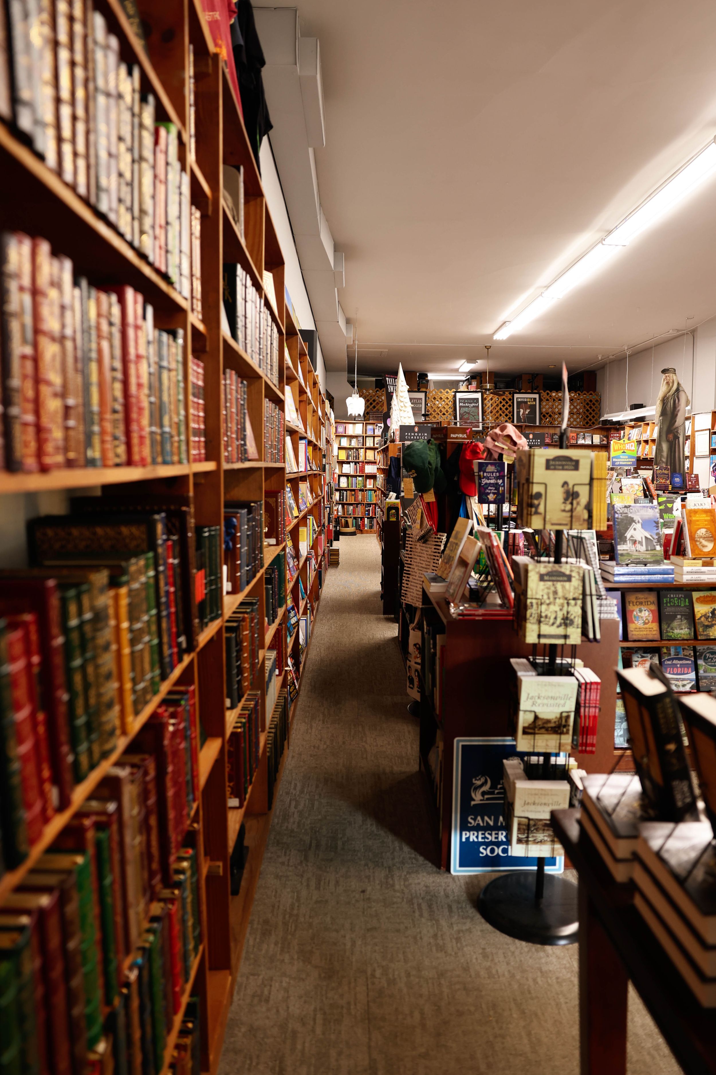 Cozy narrow aisle in a bookstore with wooden shelves filled with vintage books and soft lighting creating an intimate atmosphere.
