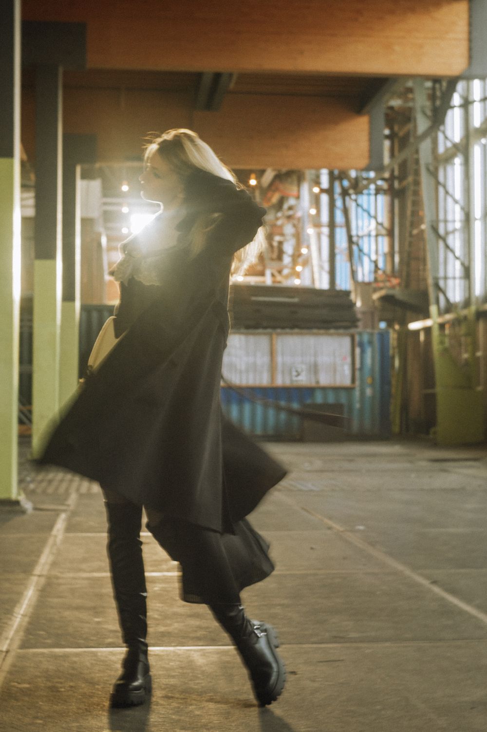 Silhouette of a person walking through an indoor space with dramatic lighting and shadows.