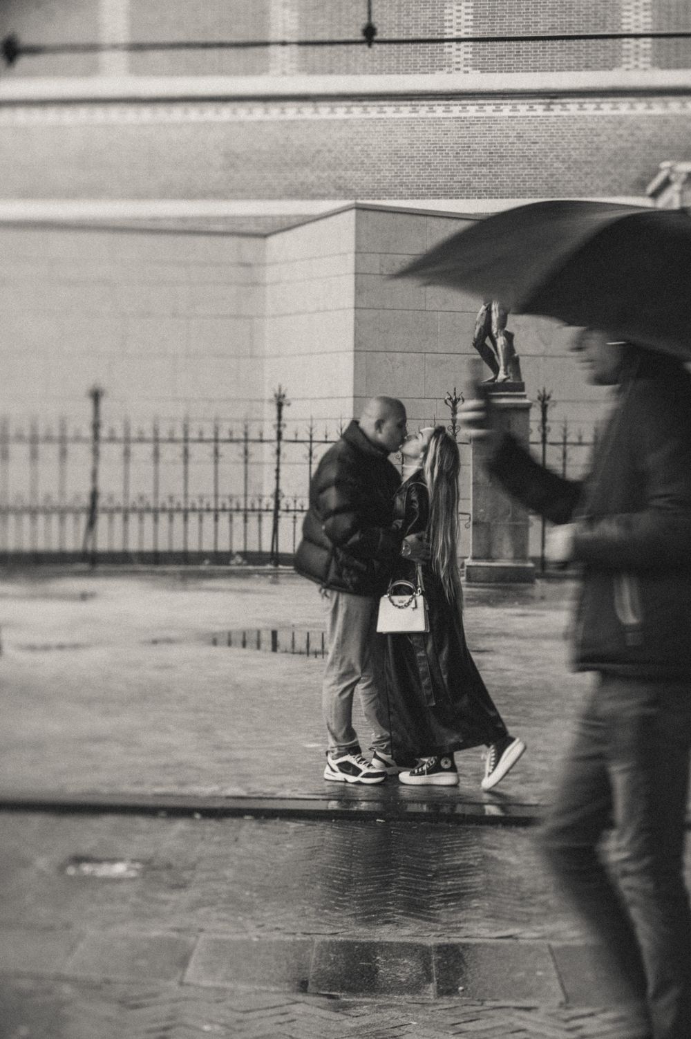 Rainy day street scene with umbrellas and blurred motion in black and white.