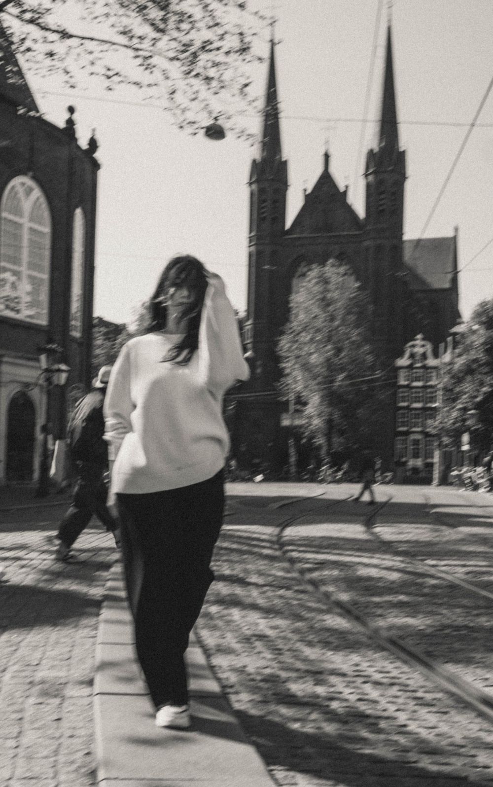Figure walking along path with gothic church spires visible in background.