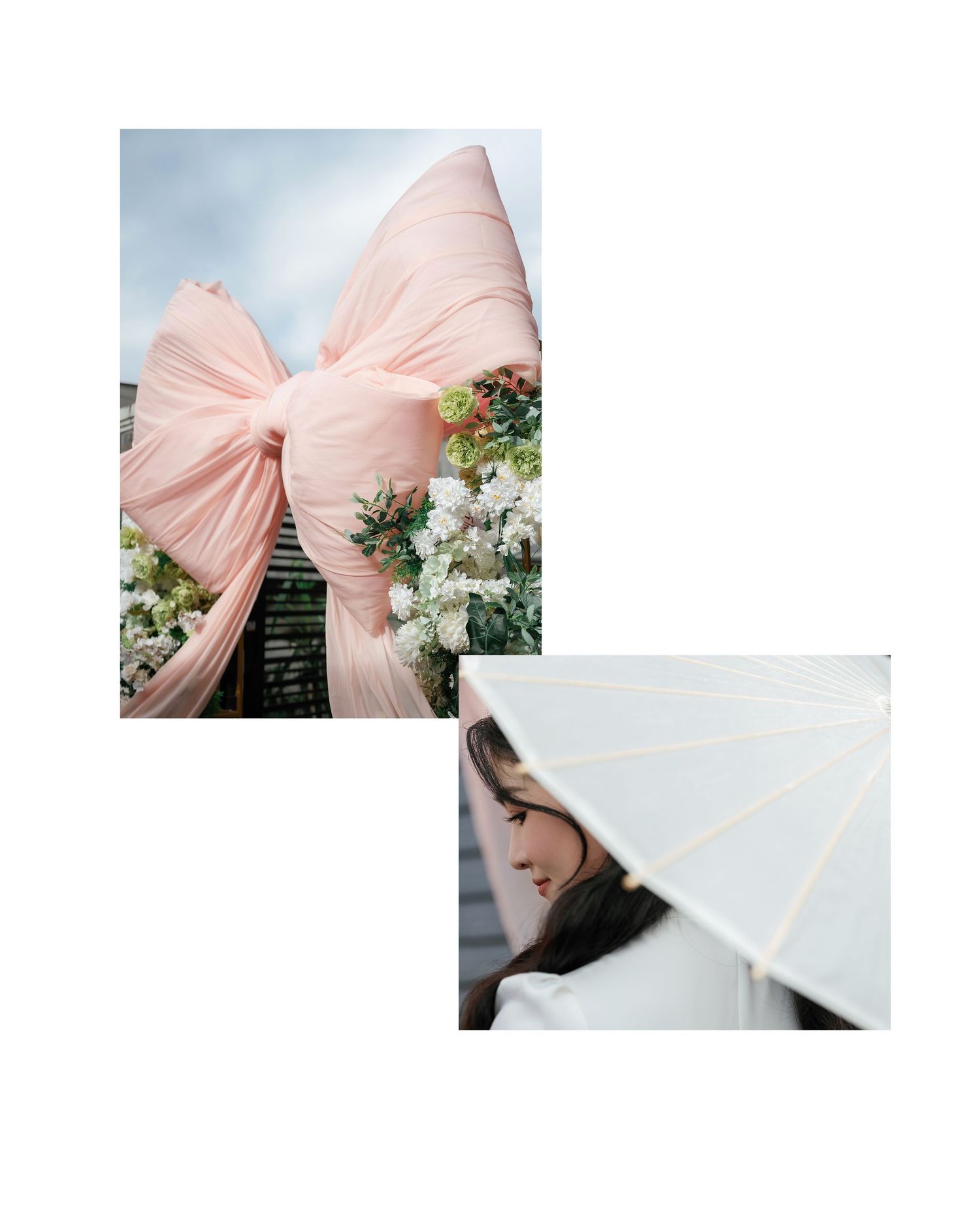 A large blush pink fabric bow decorates an outdoor wedding arch beside a white paper parasol held at an elegant angle.