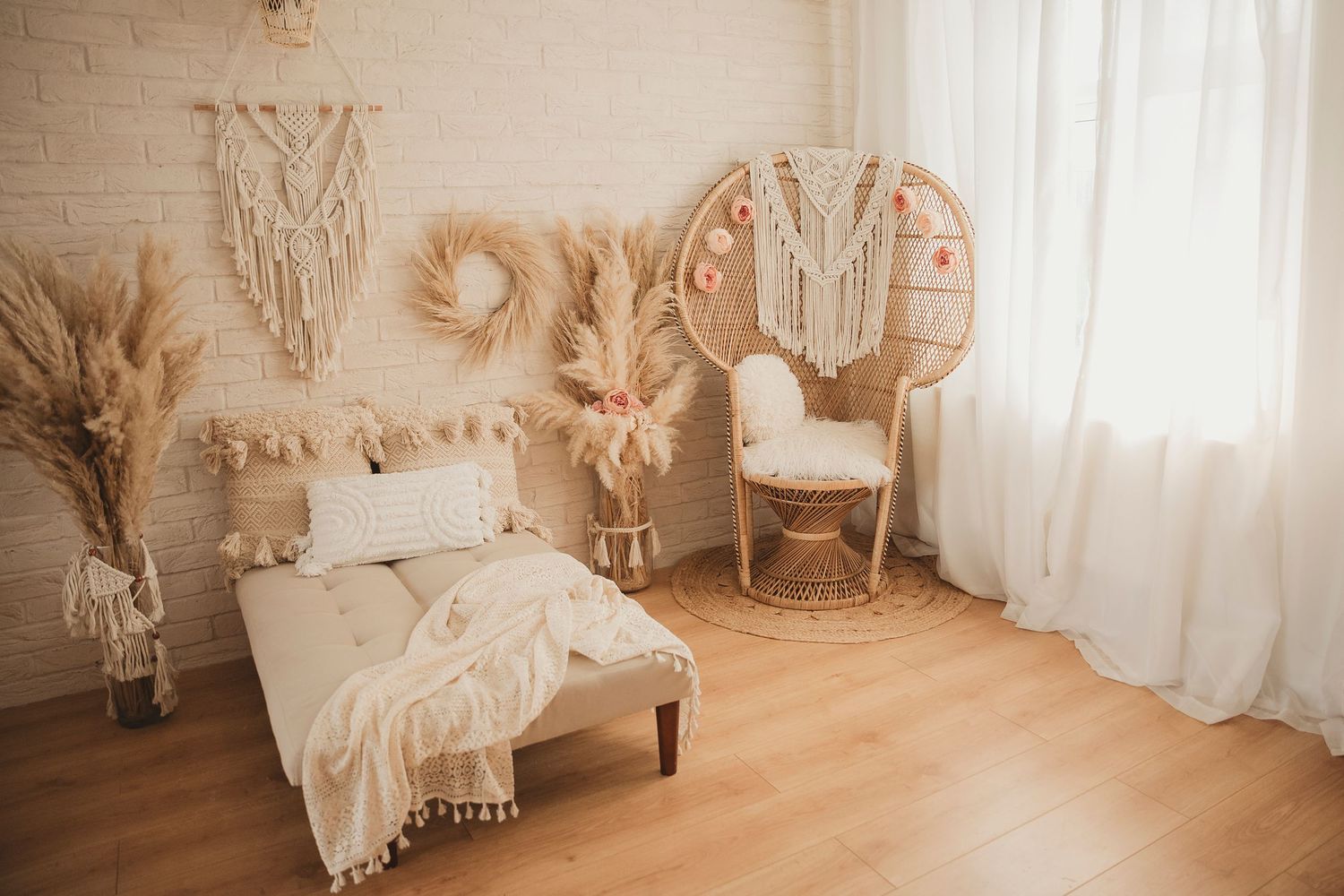 Cozy boho bedroom corner featuring a peacock chair, macrame wall hanging, pampas grass and neutral textured bedding.