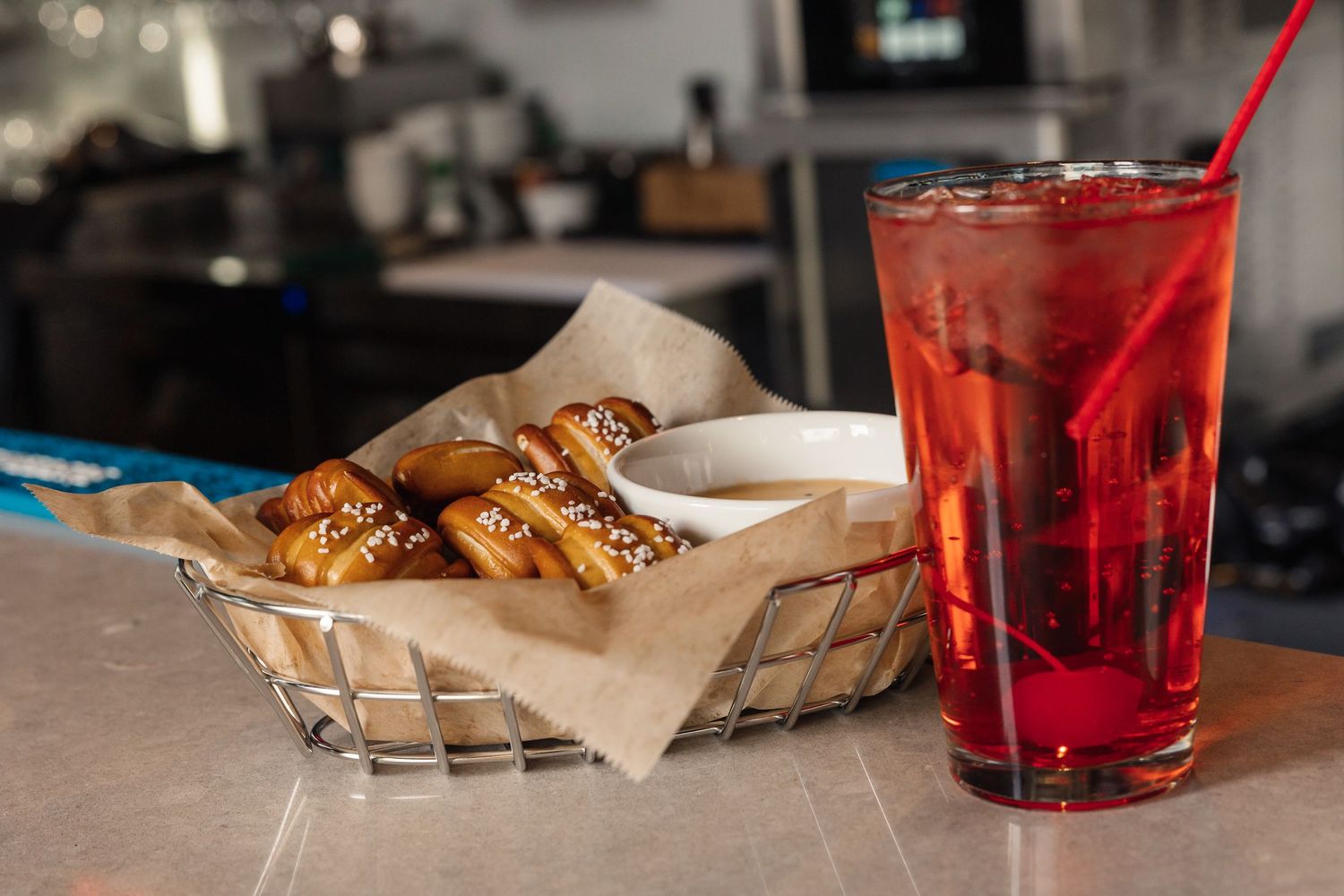Soft-focused closeup of restaurant table with pastries and beverages in warm lighting.