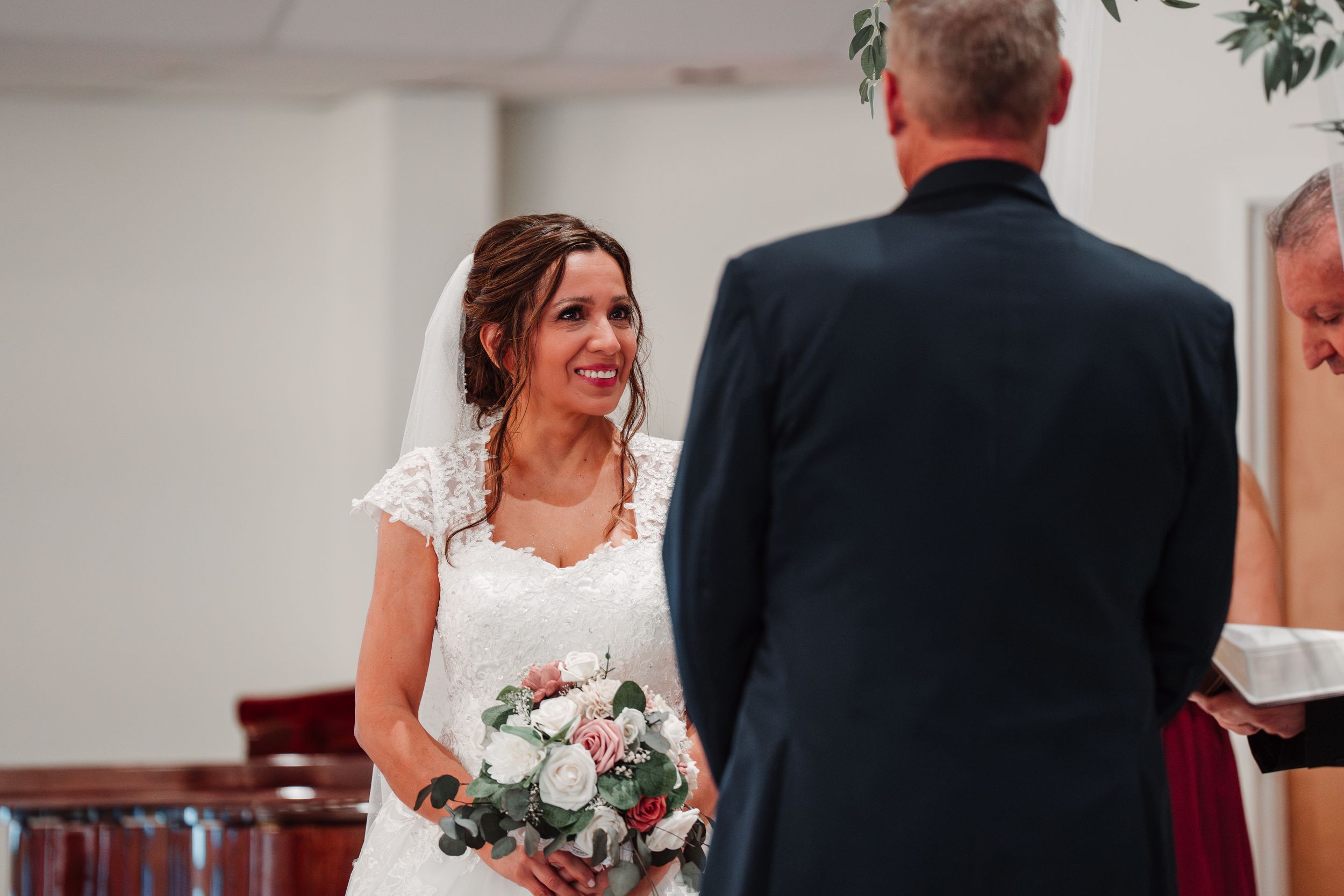 A tender wedding ceremony moment with white bouquet.