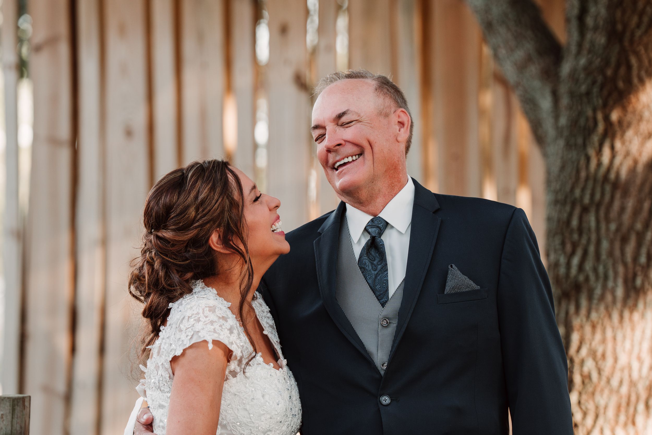 A candid moment between two people in formal attire at a rustic venue.