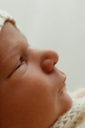 Close-up profile view of a sleeping baby's face with soft lighting.