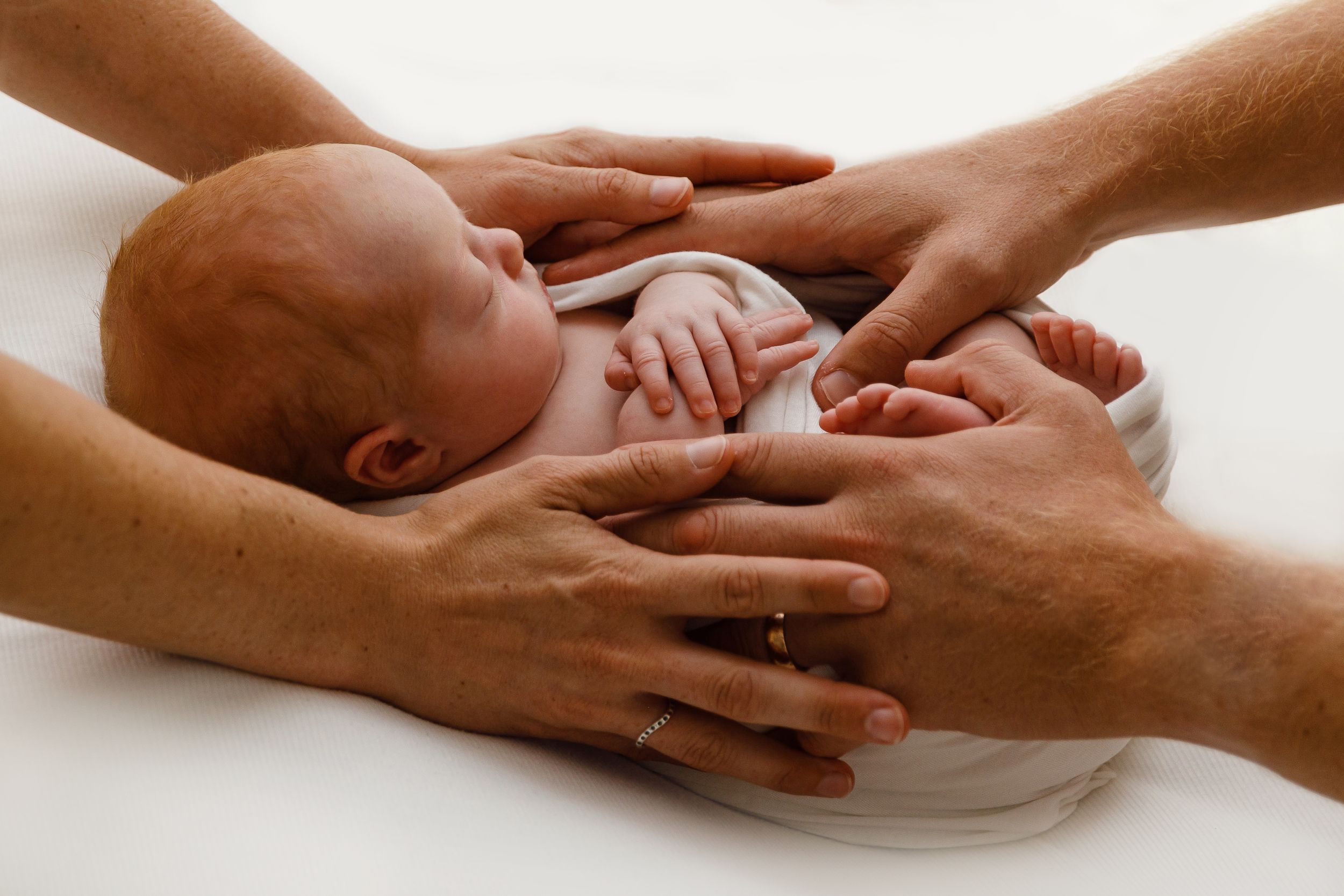 A set of caring hands providing gentle massage and touch therapy to a resting patient.