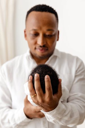 A tender moment captured as a person in a white shirt cradles a small baby.