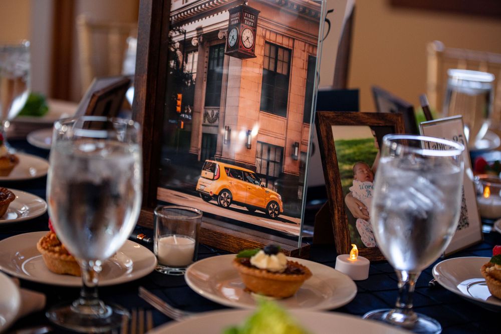 Vintage orange car photograph displayed on formal dinner table with place settings.