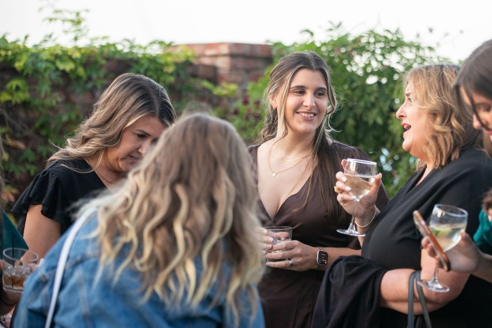 Group of friends enjoying drinks at an outdoor social gathering.