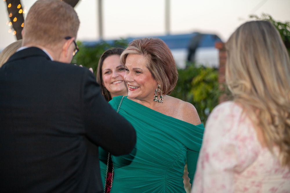 Outdoor evening celebration with guests in formal attire.