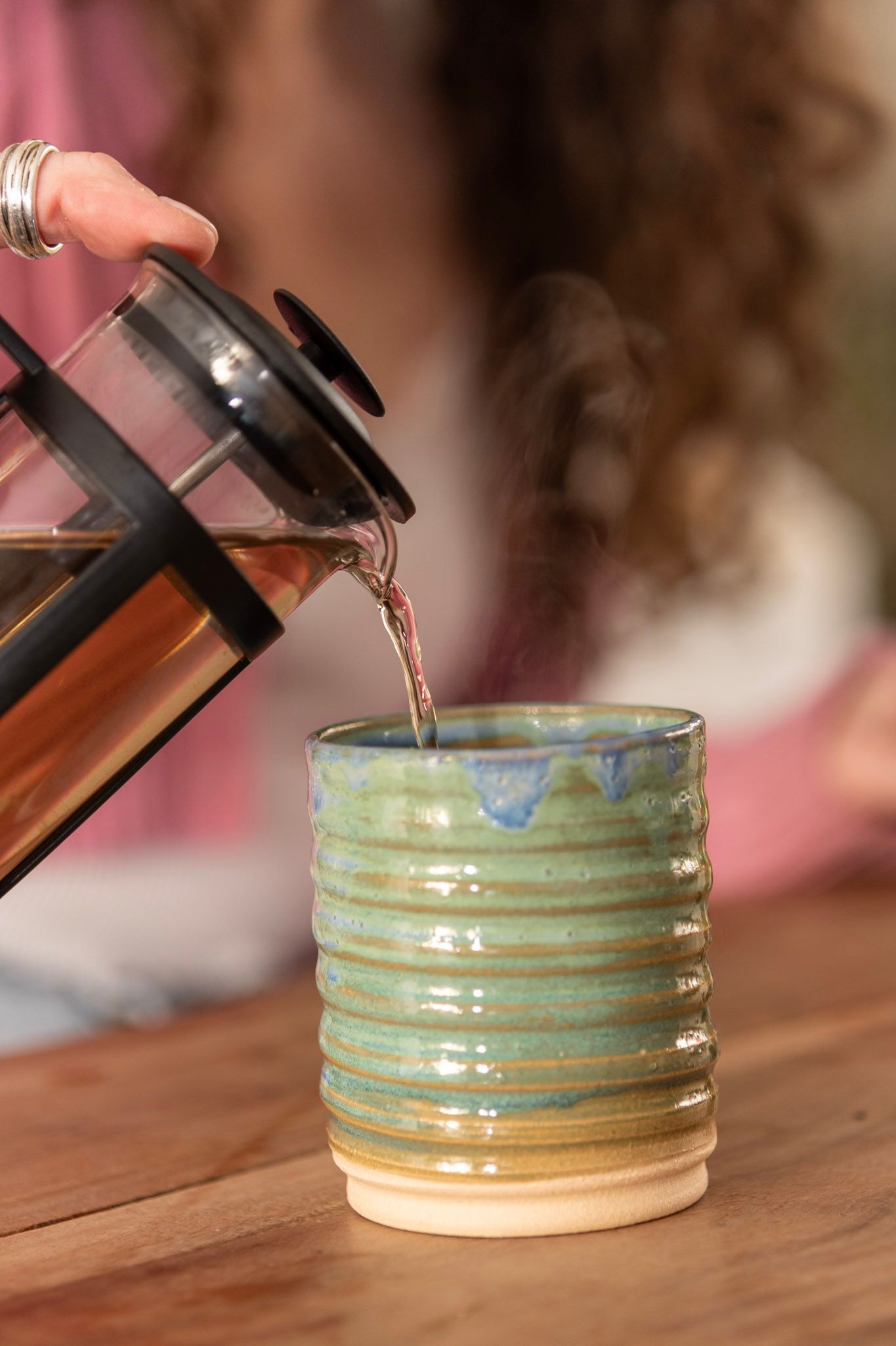 Woman pouring tincture into ceramic cup.