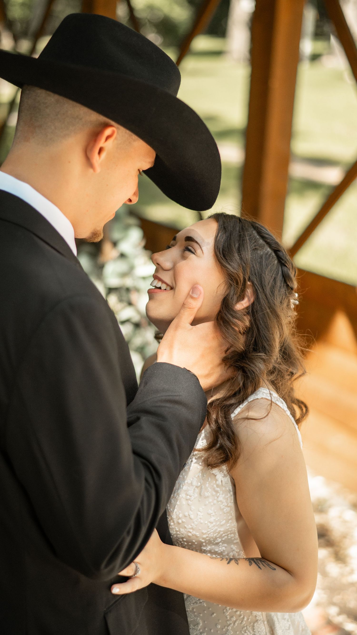 A romantic wedding moment features a beautiful bouquet of pink roses, greenery and fall colored florals.