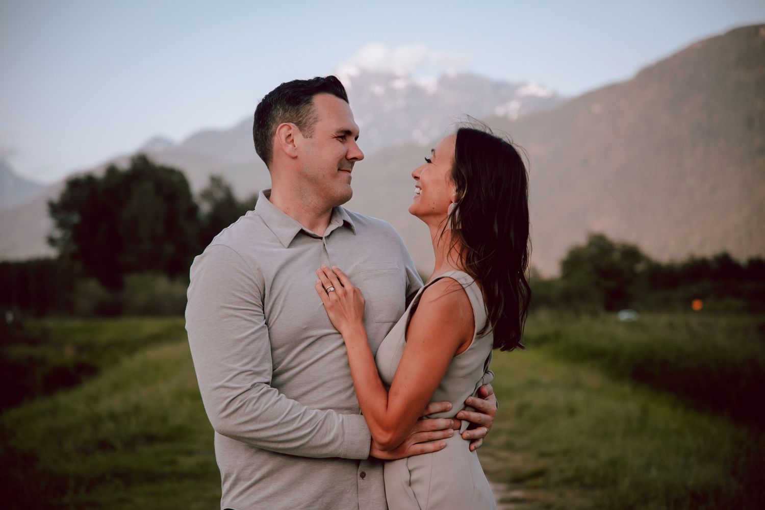Couple sharing an intimate moment against a backdrop of mountain peaks at dusk.