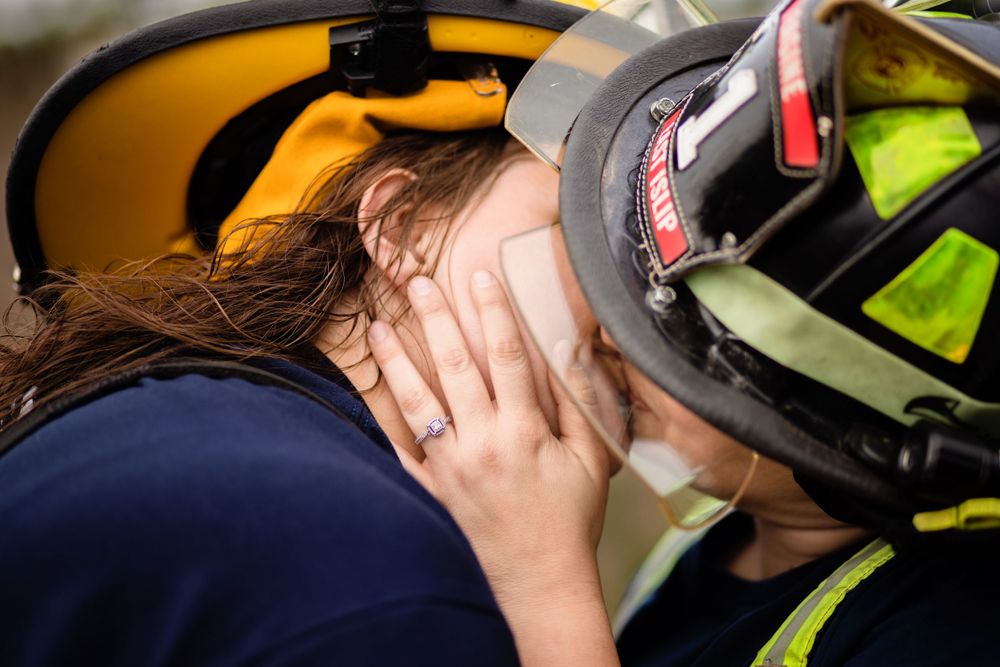 A first responder in reflective safety gear and helmet attends to someone having a medical emergency.