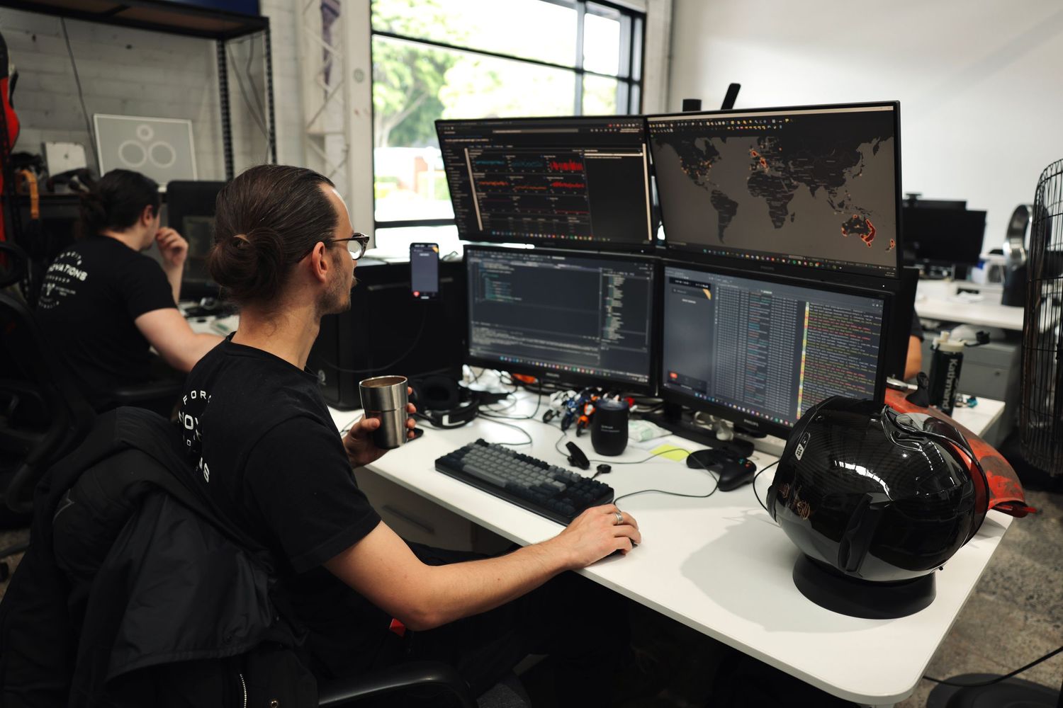 Computer workstations in an office space with multiple monitors and equipment on desks.