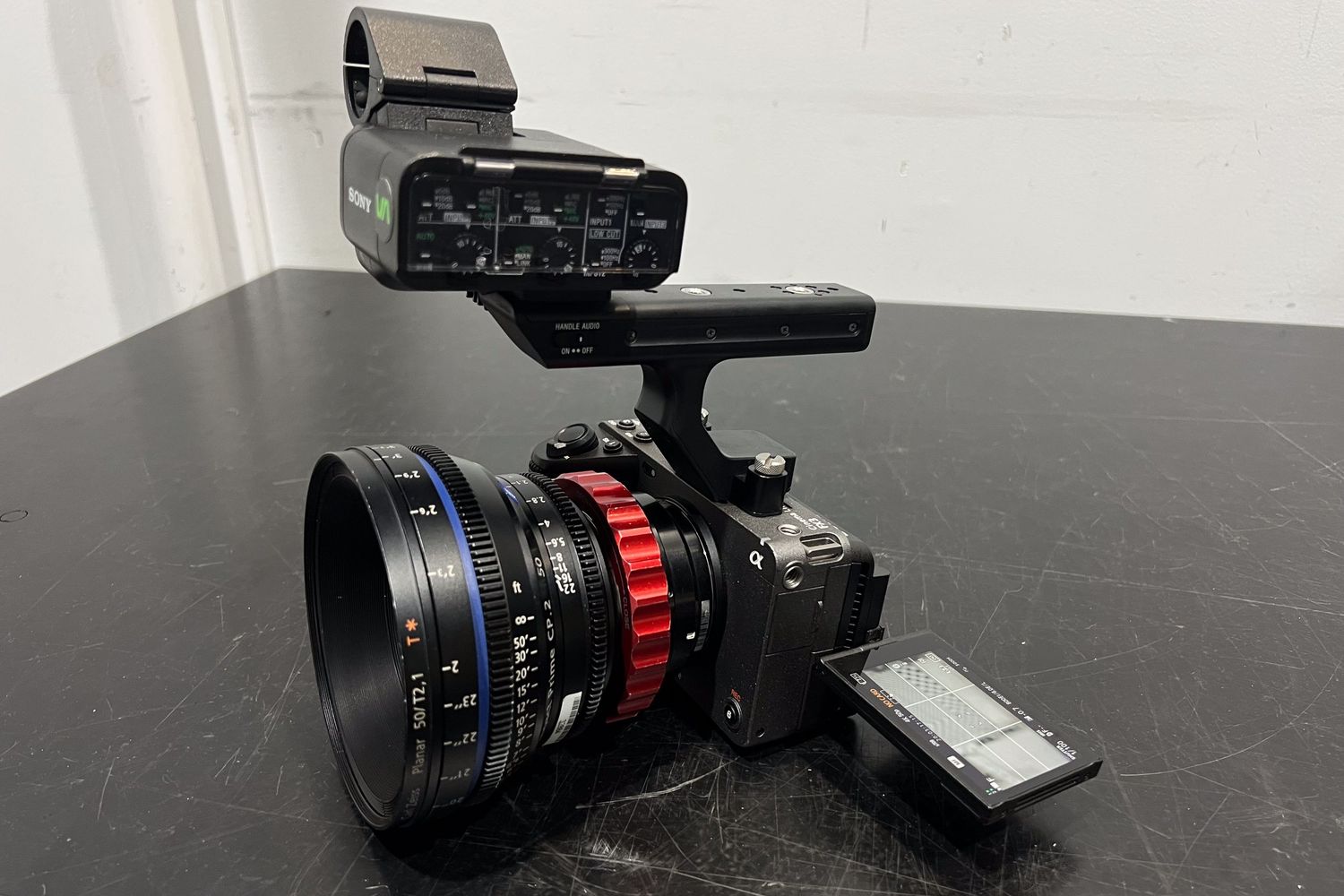 Professional camera equipment and lenses arranged on a dark surface.