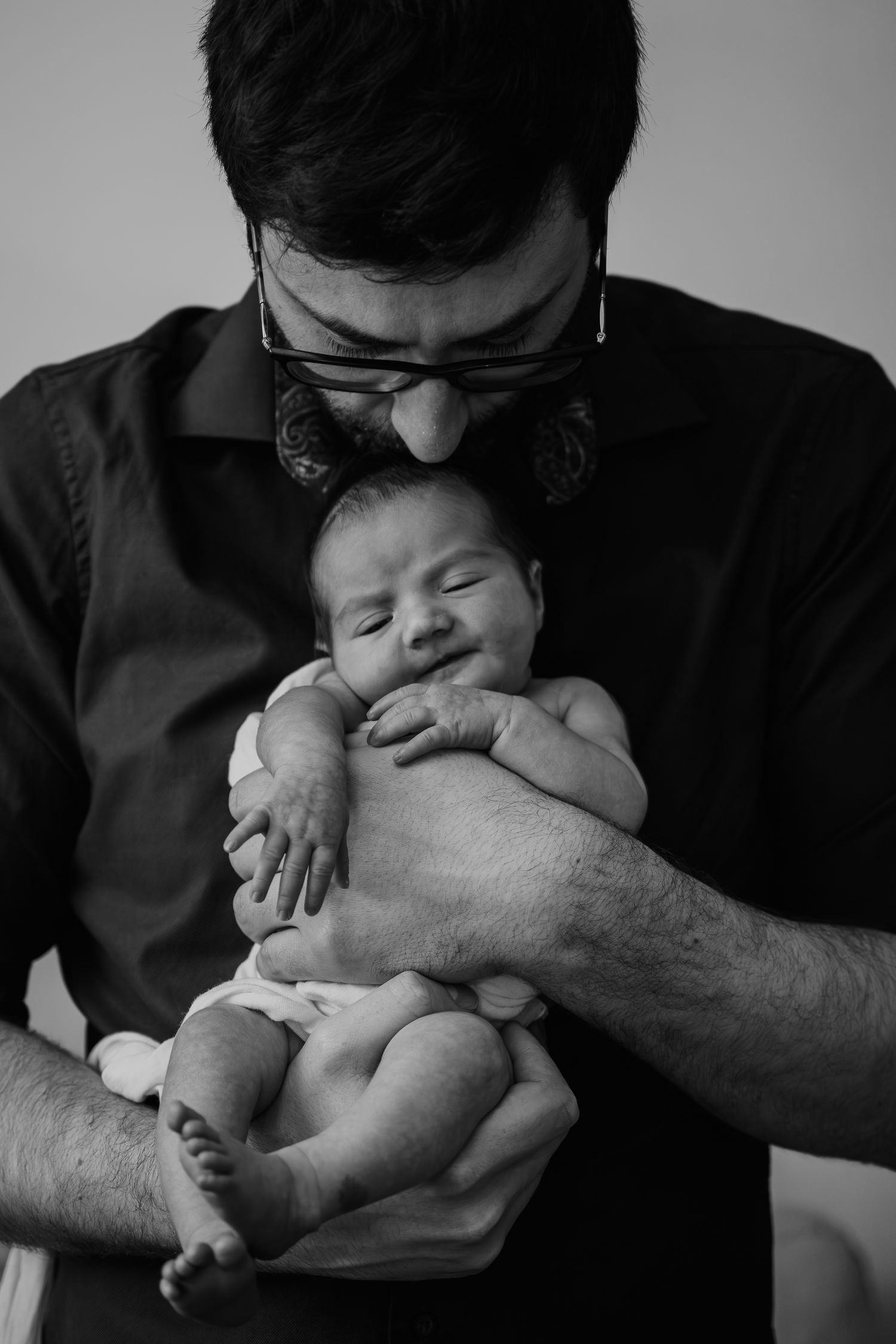 Newborn Photography - A series of black and white close-up photos showing tiny baby feet resting on soft white textured fabric.