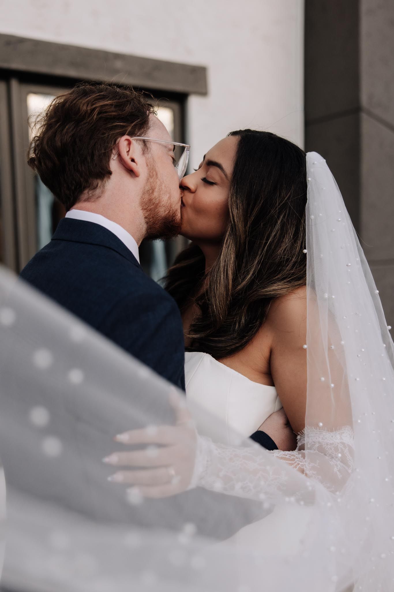 A romantic wedding sequence showing a couple sharing a kiss through a flowing white veil.