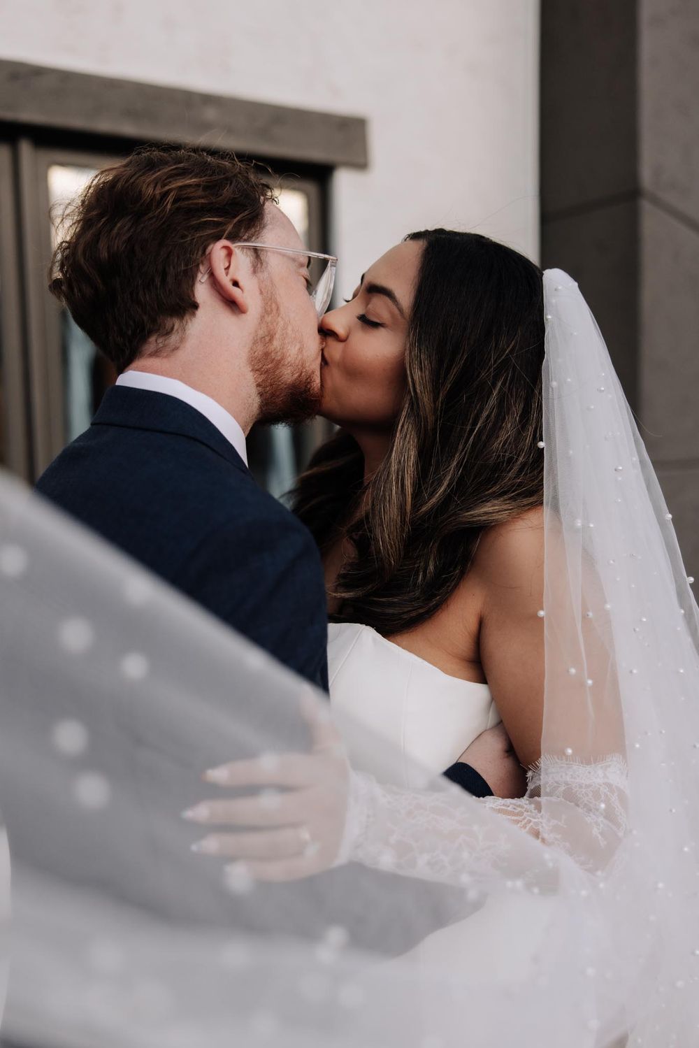 A romantic wedding sequence showing a couple sharing a kiss through a flowing white veil.