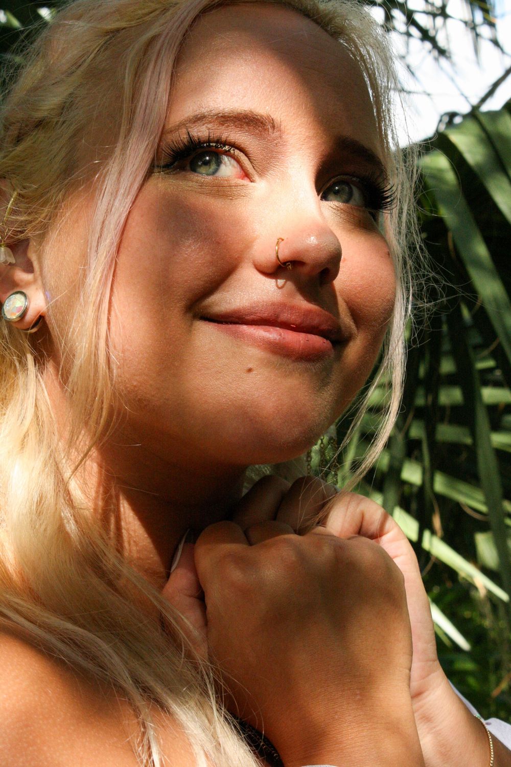 Close-up artistic portrait series showing contemplative expressions against a natural green background.