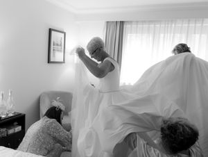Healthcare workers in protective gear assist patients in a medical facility during treatment procedures.