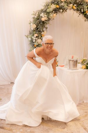 A bride in a flowing white wedding gown twirls and dances in a sequence of five elegant poses.