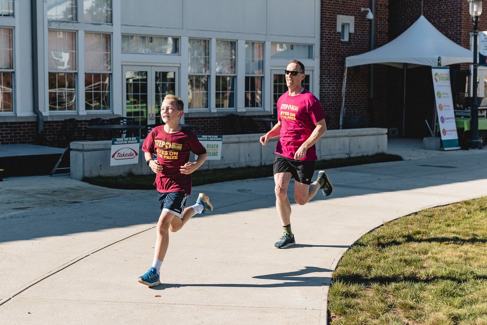 Athletes in colorful attire run along a curved path during an outdoor competition event.