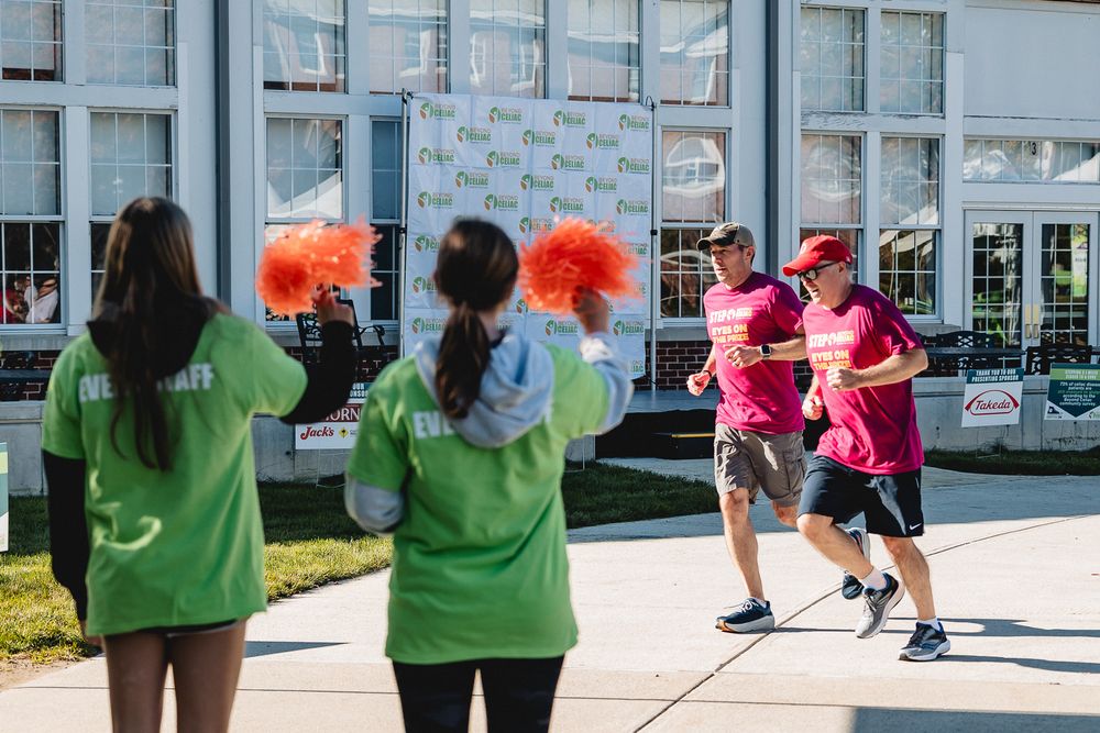 Participants in bright green and pink shirts gather outdoors during a community event.